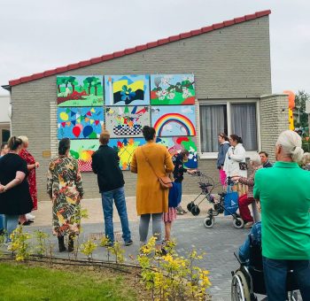 Bewoners kijkend bij de schilderplaten.